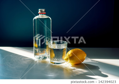 Water bottle, glass, and lemon creating refreshing beverage Water bottle, glass, and lemon creating refreshing beverage 142394023