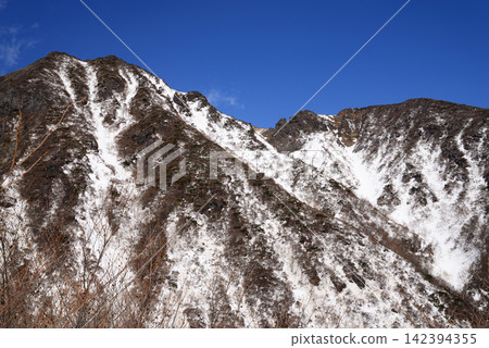 栃木縣那須山:四月晴朗的藍天映襯著巍峨的岩石山峰,山上殘存的積雪正在融化。 栃木縣那須山:四月晴朗的藍天映襯著巍峨的岩石山峰,山上殘存的積雪正在融化。 142394355