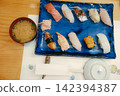 A Japanese meal consisting of a platter of fresh nigiri sushi and miso soup. 142394387