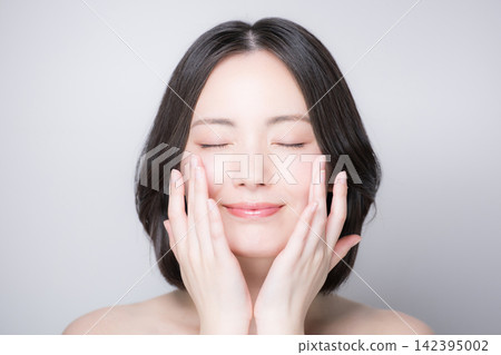 一張日本美女的特寫肖像，她面帶微笑，雙眼緊閉，展現了她完美無瑕的肌膚和自然的妝容。 142395002