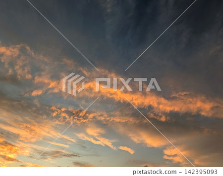 傍晚的天空宛如一幅由深紅色雲朵和烏雲交織而成的錦繡畫卷。 傍晚的天空宛如一幅由深紅色雲朵和烏雲交織而成的錦繡畫卷。 142395093