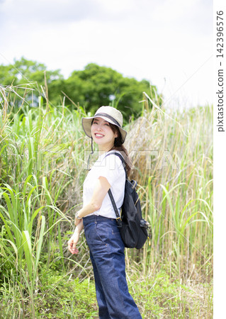 A woman strolling through a grassland or riverbank. A woman strolling through a grassland or riverbank. 142396576
