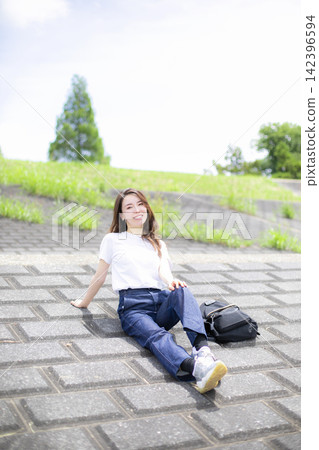 A woman strolling through a grassland or riverbank. A woman strolling through a grassland or riverbank. 142396594