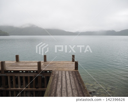 Nikko, Lake Chuzenji: A beautiful scene of a tranquil lakeside and wooden pier shrouded in mist and fog. Nikko, Lake Chuzenji: A beautiful scene of a tranquil lakeside and wooden pier shrouded in mist and fog. 142396626