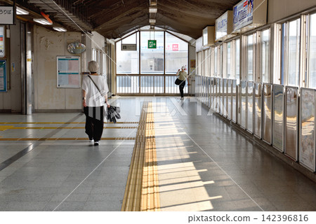 一名女子走在JR三川車站的檢票口前。 一名女子走在JR三川車站的檢票口前。 142396816