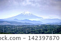 一座雄偉的雪山聳立在雲層之上，雲層中覆蓋著一團帽狀雲。 142397870