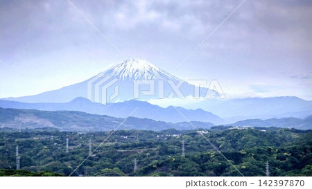 一座雄偉的雪山聳立在雲層之上，雲層中覆蓋著一團帽狀雲。 142397870