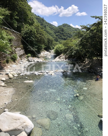 A refreshing summer landscape created by the clear, crystal-clear stream and the lush green mountains. 142398027