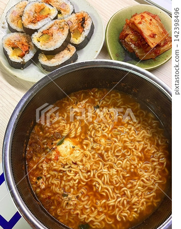 Spicy Shin ramyeon with bold, flavorful broth, served alongside fresh kimbap and tangy kimchi. A perfect trio of comforting, savory, and spicy Korean favorites in every bite. 142398496