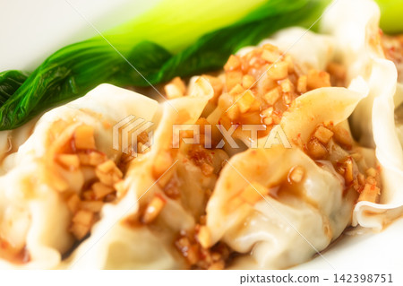Dumplings with a rich and flavorful sauce 142398751