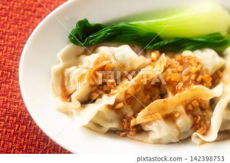 Dumplings with a rich and flavorful sauce 142398753