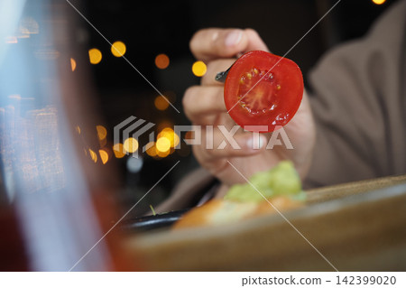 Person with a red tomato in a restaurant Person with a red tomato in a restaurant 142399020