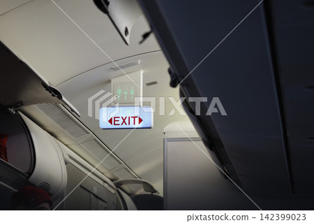 Exit sign inside an airplane cabin during flight 142399023