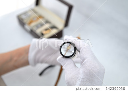 Image of an appraiser evaluating a watch Image of an appraiser evaluating a watch 142399038