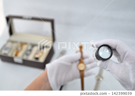Image of an appraiser evaluating a watch Image of an appraiser evaluating a watch 142399039