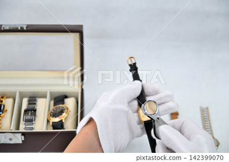 Image of an appraiser evaluating a watch 142399070