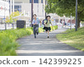 Children with school bags running along the sidewalk on their way to school. 142399225