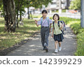 Children in school bags walk side-by-side along the school route. 142399229