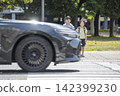 Children crossing a pedestrian crossing and cars driving by. 142399230