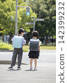 Children in school backpacks waiting in front of a crosswalk. 142399232