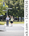 Children in school backpacks crossing a pedestrian crossing. 142399236