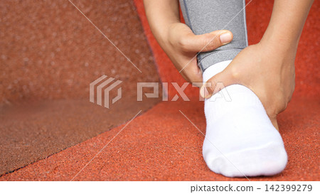 A woman with a leg ache, she is running in the park. A woman with a leg ache, she is running in the park. 142399279