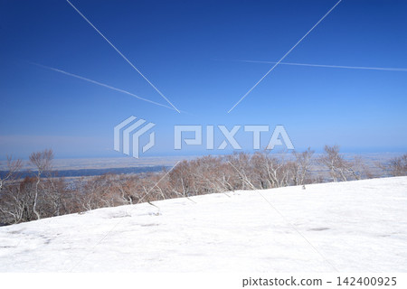 Two contrails in the blue sky above the summit of Mt. Suganadake in Gosen City, Niigata Prefecture, as spring approaches. Two contrails in the blue sky above the summit of Mt. Suganadake in Gosen City, Niigata Prefecture, as spring approaches. 142400925