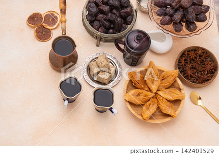 Oriental sweets and coffee on the table. Baklava, halva for dessert. Food and drink. Dates fruit Oriental sweets and coffee on the table. Baklava, halva for dessert. Food and drink. Dates fruit 142401529