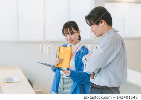 辦公室場景:女員工們正在一起審查業務文件。 辦公室場景:女員工們正在一起審查業務文件。 142401548