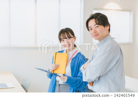 一個商業場景,畫面中一名男員工雙手交叉抱在胸前,一名女員工面帶微笑,直視鏡頭。 一個商業場景,畫面中一名男員工雙手交叉抱在胸前,一名女員工面帶微笑,直視鏡頭。 142401549