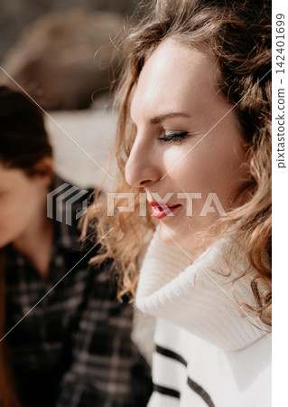 Woman Profile Curly hair peaceful model with red lips and striped sweater outdoors enjoying the sunlit autumn afternoon 142401699