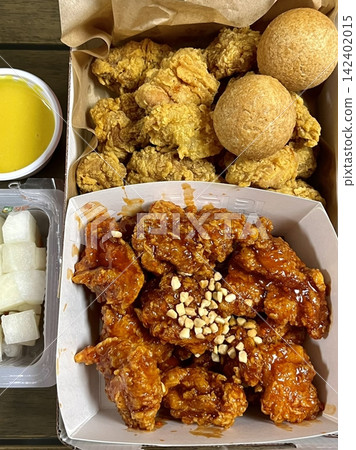 Crispy Korean fried chicken, perfectly glazed with a sweet and spicy sauce. Ideal for food photography and menus, showcasing the irresistible crunch and flavor of this beloved dish. Crispy Korean fried chicken, perfectly glazed with a sweet and spicy sauce. Ideal for food photography and menus, showcasing the irresistible crunch and flavor of this beloved dish. 142402015