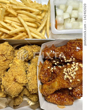 Crispy Korean fried chicken, perfectly glazed with a sweet and spicy sauce. Ideal for food photography and menus, showcasing the irresistible crunch and flavor of this beloved dish. Crispy Korean fried chicken, perfectly glazed with a sweet and spicy sauce. Ideal for food photography and menus, showcasing the irresistible crunch and flavor of this beloved dish. 142402020
