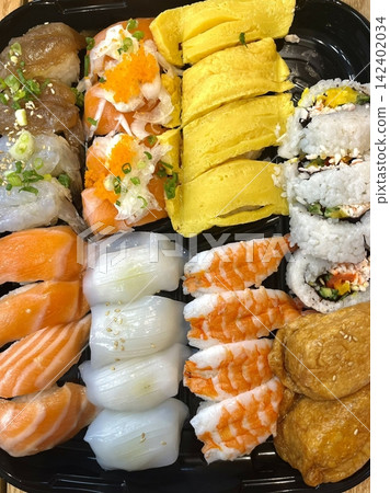 An assortment of fresh sushi, artfully arranged with a variety of toppings and vibrant colors. This traditional Japanese dish combines vinegared rice, seafood, and vegetables for an experience. An assortment of fresh sushi, artfully arranged with a variety of toppings and vibrant colors. This traditional Japanese dish combines vinegared rice, seafood, and vegetables for an experience. 142402034