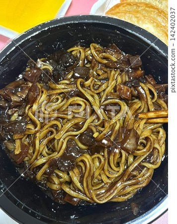 Classic jajangmyeon with thick noodles in a rich black bean sauce, garnished with sliced cucumber and sesame seeds. A beloved Korean-Chinese comfort dish, full of savory depth and flavor. Classic jajangmyeon with thick noodles in a rich black bean sauce, garnished with sliced cucumber and sesame seeds. A beloved Korean-Chinese comfort dish, full of savory depth and flavor. 142402037