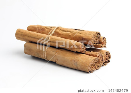 Cinnamon sticks tied with string on white background Cinnamon sticks tied with string on white background 142402479