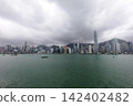 City skyline with tall buildings and boats in a harbor 142402482