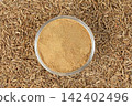 Close-up of a glass of iced coffee on a bed of coffee beans 142402496