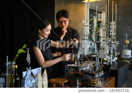 Asian Barista Couple Preparing Specialty Coffee at Artisan Cafe Bar with Scientific Brewing Equipment 142402538