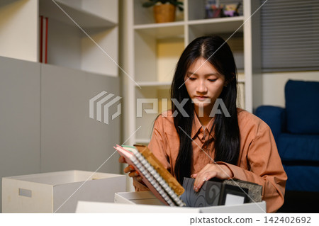 Young Asian Businesswoman Packing Personal Belongings in Box After Resignation from Office Job Young Asian Businesswoman Packing Personal Belongings in Box After Resignation from Office Job 142402692