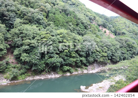 從京都嵯峨野觀光鐵道上看到的寶津峽清新翠綠的景色。 從京都嵯峨野觀光鐵道上看到的寶津峽清新翠綠的景色。 142402854
