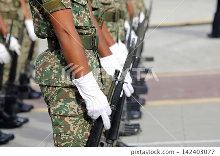 Soldier in camouflage uniform holding rifle on patrol Soldier in camouflage uniform holding rifle on patrol 142403077