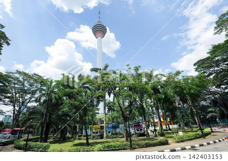 Tall tower with observation deck above green trees under blue sky Tall tower with observation deck above green trees under blue sky 142403153