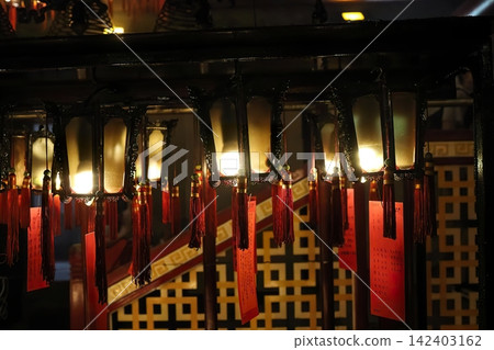 Traditional chinese lanterns hanging in a dark room Traditional chinese lanterns hanging in a dark room 142403162