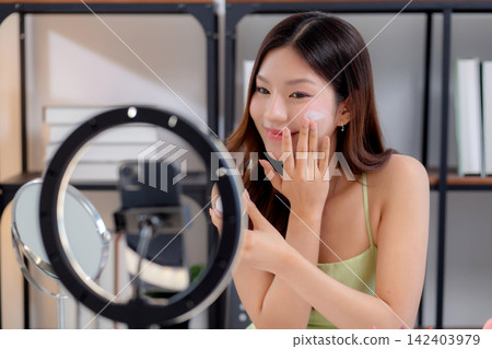 Young asian woman presenting and review cosmetic product with excitement on social media. Young asian woman presenting and review cosmetic product with excitement on social media. 142403979