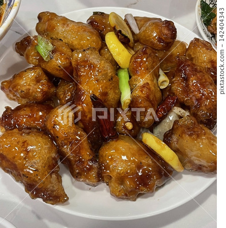 Crispy Korean fried chicken, perfectly glazed with a sweet and spicy sauce. Ideal for food photography and menus, showcasing the irresistible crunch and flavor of this beloved dish. Crispy Korean fried chicken, perfectly glazed with a sweet and spicy sauce. Ideal for food photography and menus, showcasing the irresistible crunch and flavor of this beloved dish. 142404343