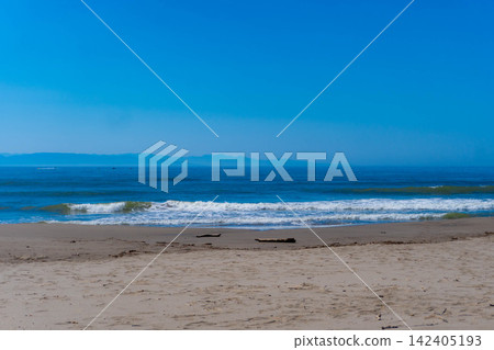 寧靜的海岸線和沙灘在藍天下綿延展開。 寧靜的海岸線和沙灘在藍天下綿延展開。 142405193