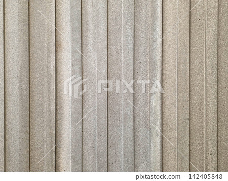 Detailed close-up view of vertical metal slabs with a rough textured finish. The beige and grey panels form a repeating geometric pattern, ideal for industrial backgrounds or architectural design. 142405848