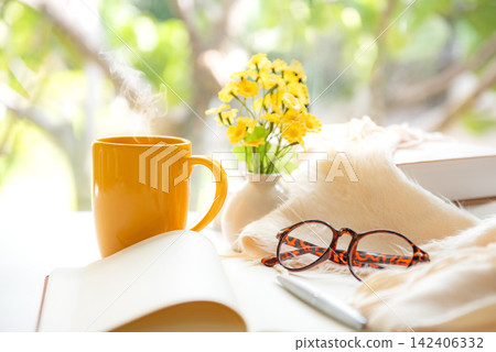 Notebook with life goals for personal growth and future planning with yellow cup coffee in warm sunshine Notebook with life goals for personal growth and future planning with yellow cup coffee in warm sunshine 142406332