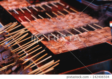 Wagyu beef skewers grilling on hot teppanyaki teppan iron plate, premium Japanese marbled meat on wooden sticks, traditional street food festival, Tokyo, Japan, market with local vendor stalls cooking Wagyu beef skewers grilling on hot teppanyaki teppan iron plate, premium Japanese marbled meat on wooden sticks, traditional street food festival, Tokyo, Japan, market with local vendor stalls cooking 142406504